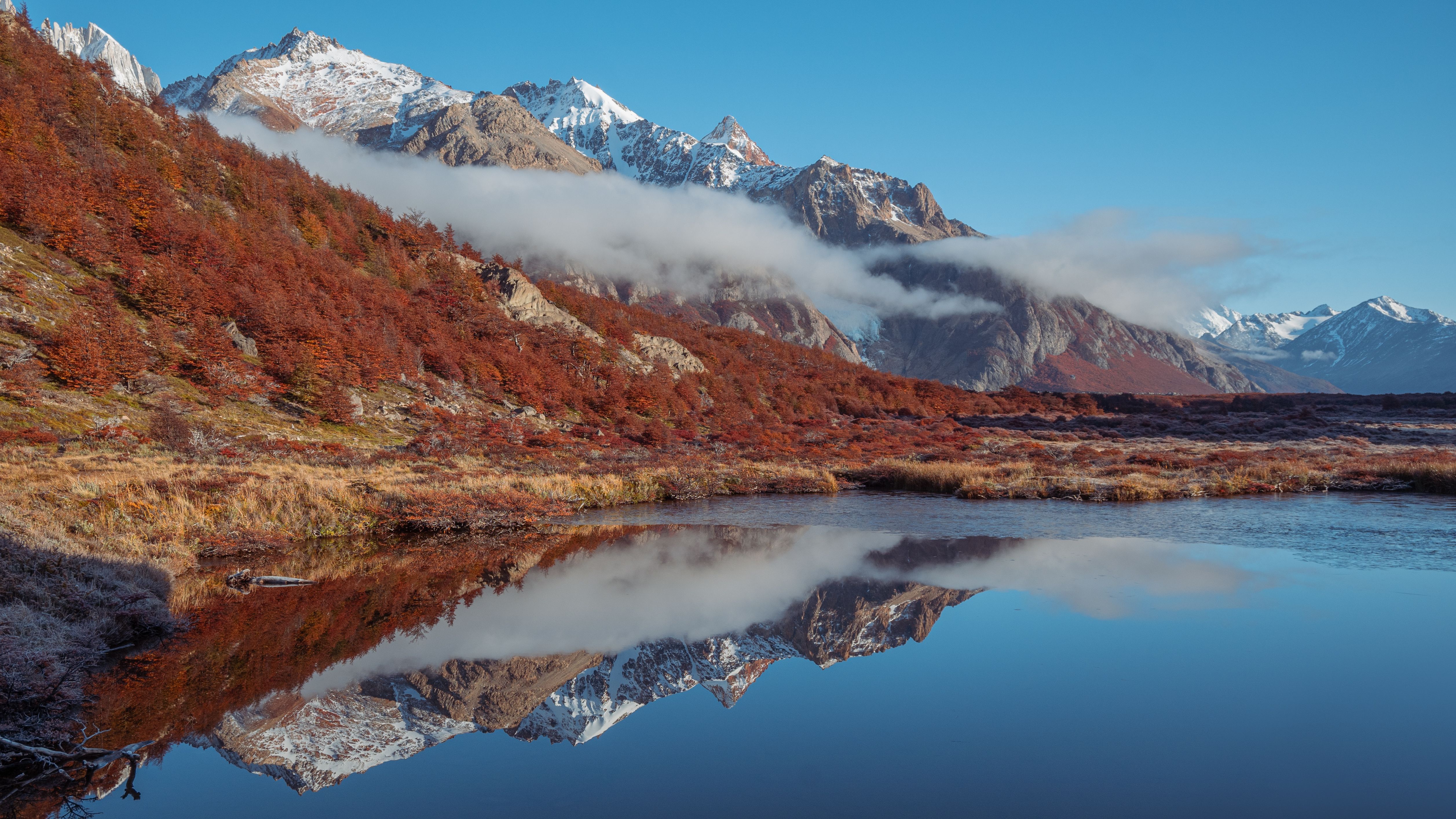 Panoramic Patagonia landscape with mountains reflected in a serene lake during autumn.