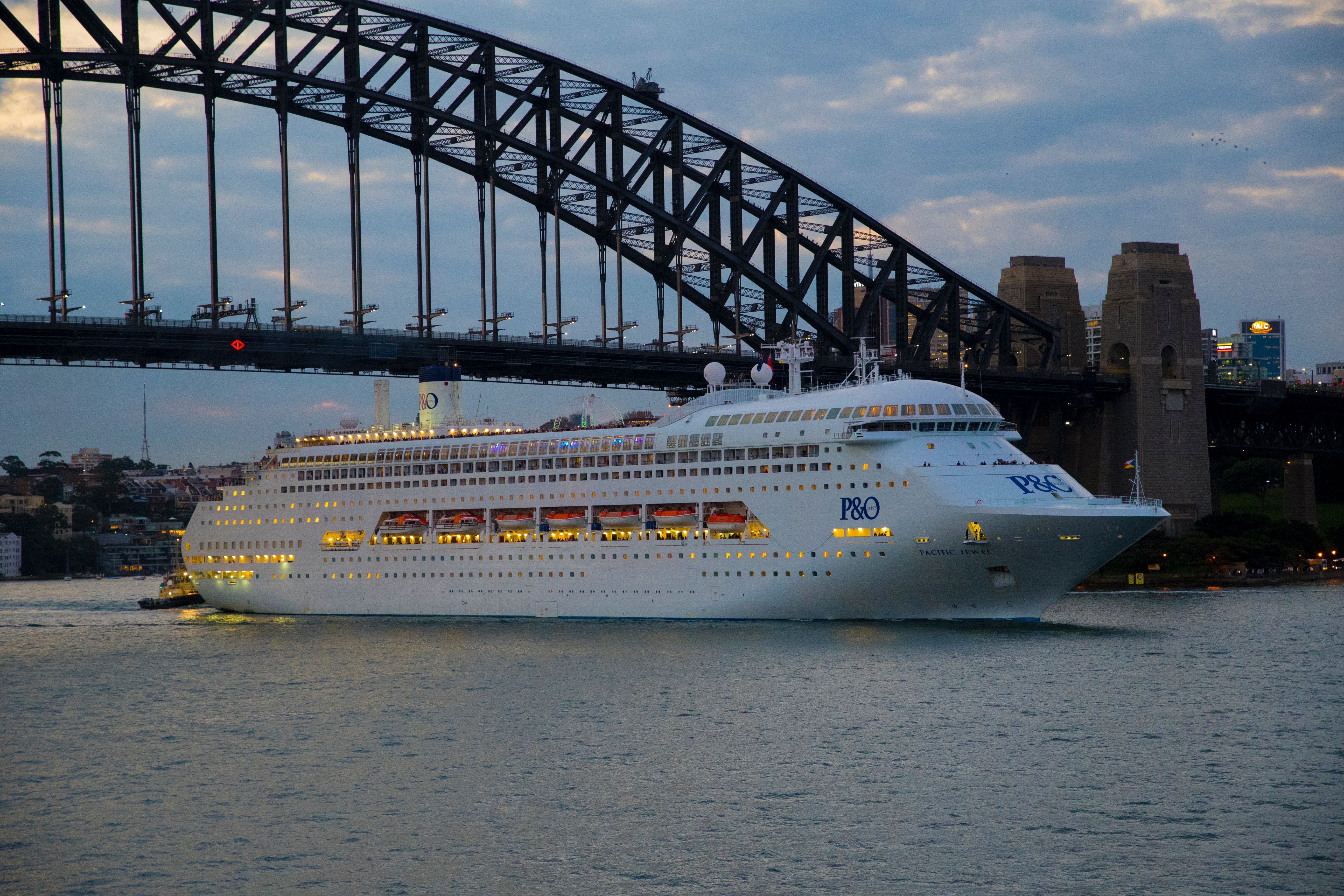 Cruise ship passing Sydney Harbour Bridge at twilight